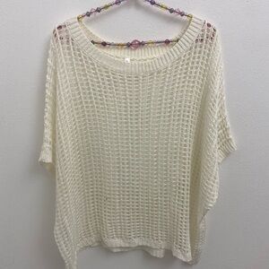 loose-knit short sleeve sweater or a crochet top. It features an open-work